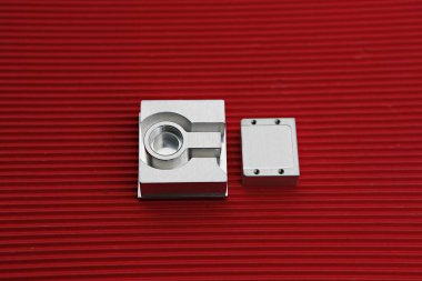 kırmızı bir yüzeyde metal bir nesne