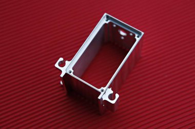 Kırmızı bir yüzey üzerinde metal bir kutu