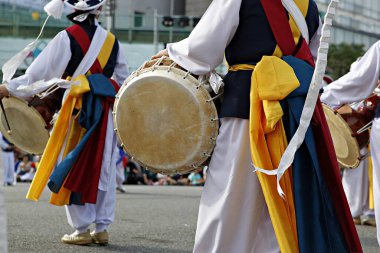 Davul çalan kostümlü bir grup insan.