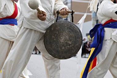 Elinde davul tutan beyaz takım elbiseli bir grup adam.