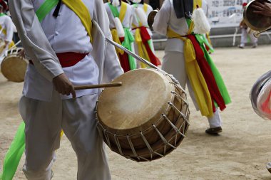 Bir tarlada davul çalan bir grup insan