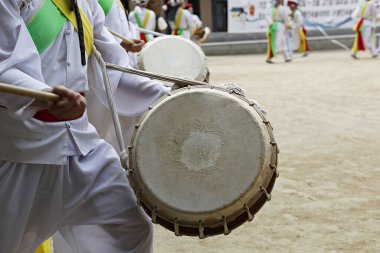 Bir tarlada davul çalan bir grup insan