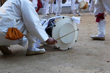 Elinde davulla diz çökmüş bir adam.