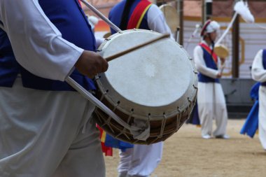 Bir grup insanın içinde davul çalan bir davulcu