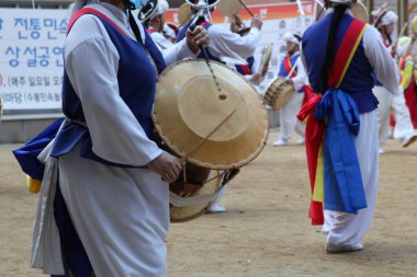 Davul çalan kostümlü bir grup insan.