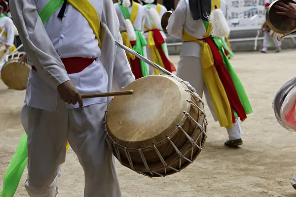 Bir tarlada davul çalan bir grup insan