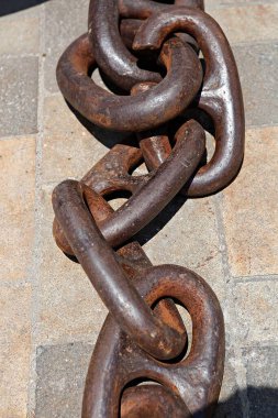 Taş duvarda paslı bir demir zincir.