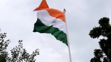 India flag flying high at Connaught Place with pride in blue sky, India flag fluttering, Indian Flag on Independence Day and Republic Day of India, tilt up shot, Waving Indian flag, Har Ghar Tiranga