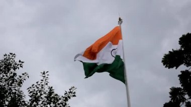 India flag flying high at Connaught Place with pride in blue sky, India flag fluttering, Indian Flag on Independence Day and Republic Day of India, tilt up shot, Waving Indian flag, Har Ghar Tiranga