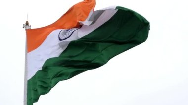 India flag flying high at Connaught Place with pride in blue sky, India flag fluttering, Indian Flag on Independence Day and Republic Day of India, tilt up shot, Waving Indian flag, Har Ghar Tiranga