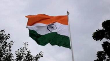 India flag flying high at Connaught Place with pride in blue sky, India flag fluttering, Indian Flag on Independence Day and Republic Day of India, tilt up shot, Waving Indian flag, Har Ghar Tiranga