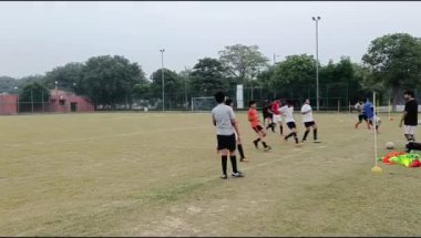 Yeni Delhi, Hindistan - 10 Mart 2024: Kötü bir futbol sahasında bölgesel Derby şampiyonasında yerel futbol takımının futbolcuları. Stadyumun çimen yeşili sahasında sıcak bir futbol maçı var.