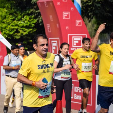 Yeni Delhi, Hindistan - 16 Ekim 2022 - Bitmek üzere olan maraton katılımcılarının bitiş çizgisini geçmek üzere olan Delhi Yarı Maratonu 2022