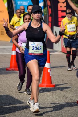 Yeni Delhi, Hindistan - 16 Ekim 2022 - Bitmek üzere olan maraton katılımcılarının bitiş çizgisini geçmek üzere olan Delhi Yarı Maratonu 2022