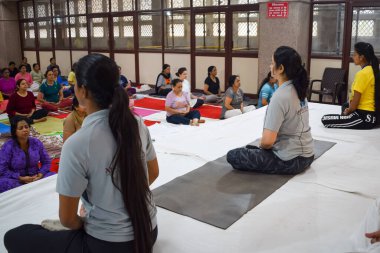 Delhi, India, June 19 2022-Group Yoga exercise session for people of different age groups in Balaji Temple,Vivek Vihar, International Yoga Day, Big group of adults attending yoga class-Black and White