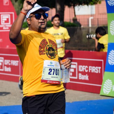 Yeni Delhi, Hindistan - 16 Ekim 2022 - Bitmek üzere olan maraton katılımcılarının bitiş çizgisini geçmek üzere olan Delhi Yarı Maratonu 2022