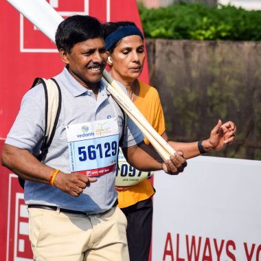 Yeni Delhi, Hindistan - 16 Ekim 2022 - Bitmek üzere olan maraton katılımcılarının bitiş çizgisini geçmek üzere olan Delhi Yarı Maratonu 2022
