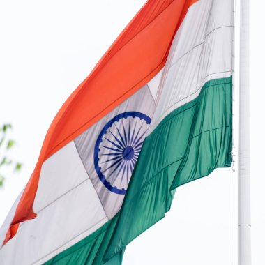 India flag flying high at Connaught Place with pride in blue sky, India flag fluttering, Indian Flag on Independence Day and Republic Day of India, tilt up shot, Waving Indian flag, Har Ghar Tiranga