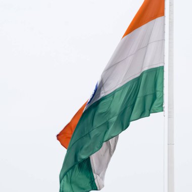 India flag flying high at Connaught Place with pride in blue sky, India flag fluttering, Indian Flag on Independence Day and Republic Day of India, tilt up shot, Waving Indian flag, Har Ghar Tiranga