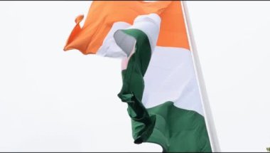 India flag flying high at Connaught Place with pride in blue sky, India flag fluttering, Indian Flag on Independence Day and Republic Day of India, tilt up shot, Waving Indian flag, Har Ghar Tiranga