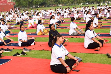 Yeni Delhi, Hindistan, 21 Haziran 2022 - Uluslararası Yoga Günü 'nde Delhi' deki Yamuna Spor Kompleksi 'nde farklı yaş gruplarındaki insanlar için grup Yoga egzersiz oturumu, kriket stadyumunda yoga sınıfına katılan büyük bir yetişkin grubu