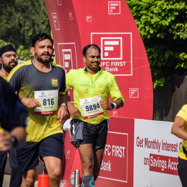 Yeni Delhi, Hindistan - 16 Ekim 2022 - Bitmek üzere olan maraton katılımcılarının bitiş çizgisini geçmek üzere olan Delhi Yarı Maratonu 2022