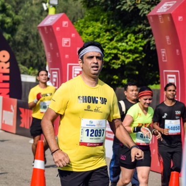 Yeni Delhi, Hindistan - 16 Ekim 2022 - Bitmek üzere olan maraton katılımcılarının bitiş çizgisini geçmek üzere olan Delhi Yarı Maratonu 2022