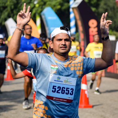 Yeni Delhi, Hindistan - 16 Ekim 2022 - Bitmek üzere olan maraton katılımcılarının bitiş çizgisini geçmek üzere olan Delhi Yarı Maratonu 2022