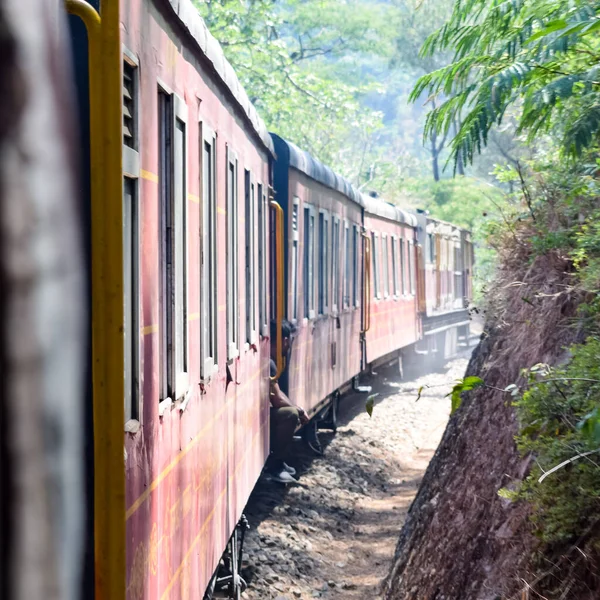 stock image Toy Train moving on mountain slopes, beautiful view, one side mountain, one side valley moving on railway to the hill, among green natural forest. Toy train from Kalka to Shimla in India, Indian Train