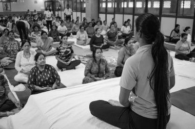 Delhi, India, June 19 2022-Group Yoga exercise session for people of different age groups in Balaji Temple,Vivek Vihar, International Yoga Day, Big group of adults attending yoga class-Black and White