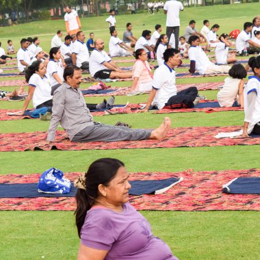 Yeni Delhi, Hindistan, 21 Haziran 2022 - Uluslararası Yoga Günü 'nde Delhi' deki Yamuna Spor Kompleksi 'nde grup Yoga egzersiz oturumu, kriket stadyumunda yoga derslerine katılan büyük bir grup yetişkin