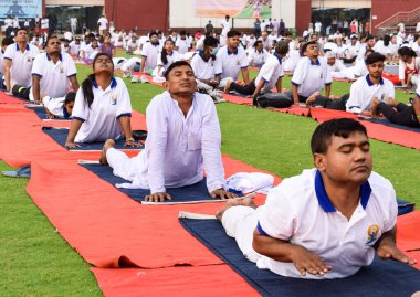 Yeni Delhi, Hindistan, 21 Haziran 2022 - Uluslararası Yoga Günü 'nde Delhi' deki Yamuna Spor Kompleksi 'nde grup Yoga egzersiz oturumu, kriket stadyumunda yoga derslerine katılan büyük bir grup yetişkin