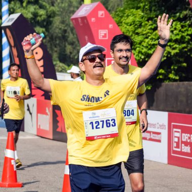 Yeni Delhi, Hindistan - 16 Ekim 2022 - Bitmek üzere olan maraton katılımcılarının bitiş çizgisini geçmek üzere olan Delhi Yarı Maratonu 2022