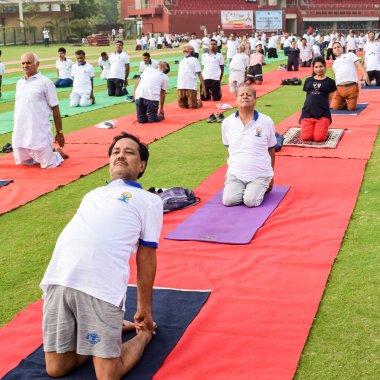 Yeni Delhi, Hindistan, 21 Haziran 2022 - Uluslararası Yoga Günü 'nde Delhi' deki Yamuna Spor Kompleksi 'nde grup Yoga egzersiz oturumu, kriket stadyumunda yoga derslerine katılan büyük bir grup yetişkin