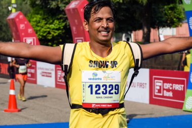 Yeni Delhi, Hindistan - 16 Ekim 2022 - Bitmek üzere olan maraton katılımcılarının bitiş çizgisini geçmek üzere olan Delhi Yarı Maratonu 2022