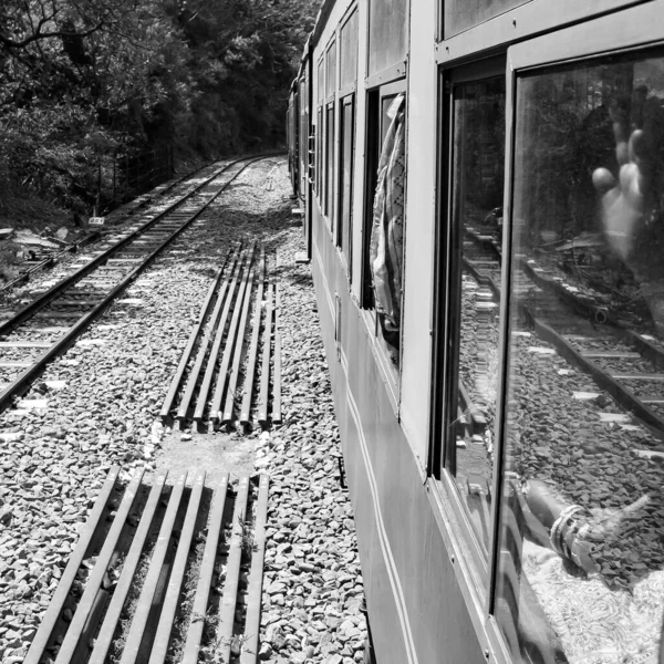 stock image Toy Train moving on mountain slope, beautiful view, one side mountain, one side valley moving on railway to the hill, among green natural forest.Toy train from Kalka to Shimla in India-Black and White