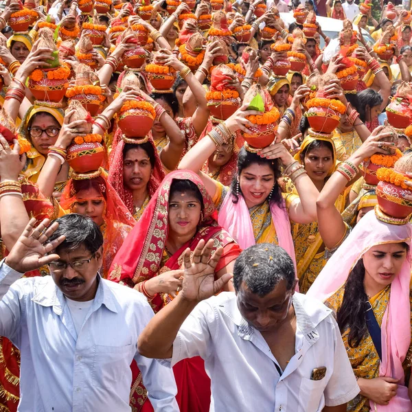 stock image New Delhi, India April 03 2022 - Women with Kalash on head during Jagannath Temple Mangal Kalash Yatra, Indian Hindu devotees carry earthen pots containing sacred water with a coconut on top