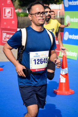 Yeni Delhi, Hindistan - 16 Ekim 2022 - Bitmek üzere olan maraton katılımcılarının bitiş çizgisini geçmek üzere olan Delhi Yarı Maratonu 2022