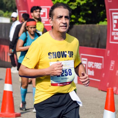 Yeni Delhi, Hindistan - 16 Ekim 2022 - Bitmek üzere olan maraton katılımcılarının bitiş çizgisini geçmek üzere olan Delhi Yarı Maratonu 2022