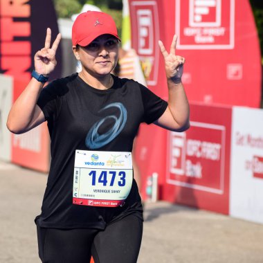 Yeni Delhi, Hindistan - 16 Ekim 2022 - Bitmek üzere olan maraton katılımcılarının bitiş çizgisini geçmek üzere olan Delhi Yarı Maratonu 2022