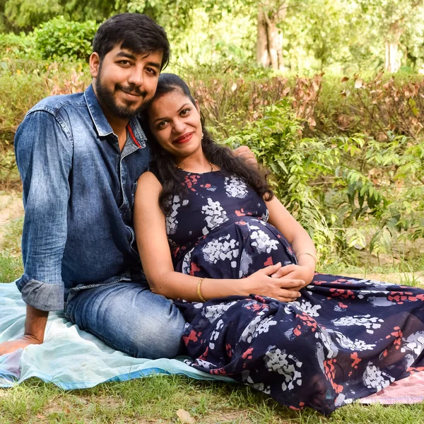 一对印度夫妇摆出生育婴儿的姿势 在印度新德里的Lodhi花园 这对夫妇正躺在草地上 草地上长满了青草 而这位女士则在摇晃着她的婴儿车颠簸着 — 图库照片