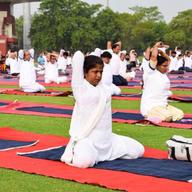 Yeni Delhi, Hindistan, 21 Haziran 2022 - Uluslararası Yoga Günü 'nde Delhi' deki Yamuna Spor Kompleksi 'nde grup Yoga egzersiz oturumu, kriket stadyumunda yoga derslerine katılan büyük bir grup yetişkin