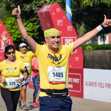 Yeni Delhi, Hindistan - 16 Ekim 2022 - Bitmek üzere olan maraton katılımcılarının bitiş çizgisini geçmek üzere olan Delhi Yarı Maratonu 2022