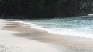 Gün batımında Crystal Körfezi 'nin manzaralı okyanus koyunda. Çarpışan dalgalar, demirlemiş tekneler, renkli günbatımı, Endonezya 'nın Bali kentinin güneydoğusundaki bir ada olan Nusa Penida' nın batı kıyısında bulunan tropikal titreşimler.