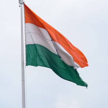 India flag flying high at Connaught Place with pride in blue sky, India flag fluttering, Indian Flag on Independence Day and Republic Day of India, tilt up shot, Waving Indian flag, Har Ghar Tiranga