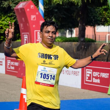 Yeni Delhi, Hindistan - 16 Ekim 2022 - Bitmek üzere olan maraton katılımcılarının bitiş çizgisini geçmek üzere olan Delhi Yarı Maratonu 2022
