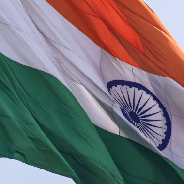 India flag flying high at Connaught Place with pride in blue sky, India flag fluttering, Indian Flag on Independence Day and Republic Day of India, tilt up shot, Waving Indian flag, Har Ghar Tiranga