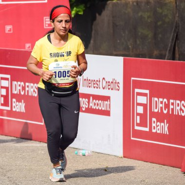 Yeni Delhi, Hindistan - 16 Ekim 2022 - Bitmek üzere olan maraton katılımcılarının bitiş çizgisini geçmek üzere olan Delhi Yarı Maratonu 2022