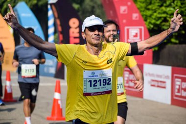 Yeni Delhi, Hindistan - 16 Ekim 2022 - Bitmek üzere olan maraton katılımcılarının bitiş çizgisini geçmek üzere olan Delhi Yarı Maratonu 2022