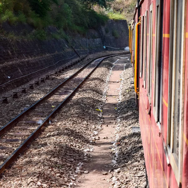 Toy Train moving on mountain slopes, beautiful view, one side mountain, one side valley moving on railway to the hill, among green natural forest. Toy train from Kalka to Shimla in India, Indian Train